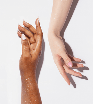 Two model hands with Eva NYC body glitter spray