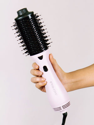 Hand holding Eva NYC's Healthy Heat 2-in-1 Lavender Blowout Brush